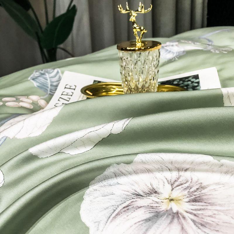 Close-up of luxurious Green Nature Duvet Cover Set (Eucalyptus Lyocell) featuring a delicate floral pattern with a decorative item on top.