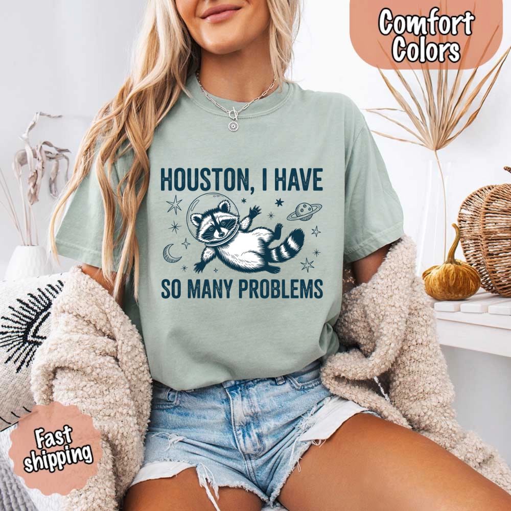 Houston I Have So Many Problems Raccoon Comfort Colors T-Shirts featuring a space raccoon design with fast shipping options.