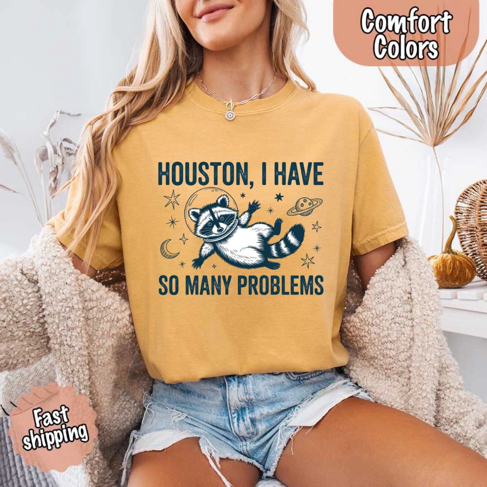 Woman wearing Houston I Have So Many Problems Raccoon Comfort Colors T-Shirts, featuring space raccoon design.