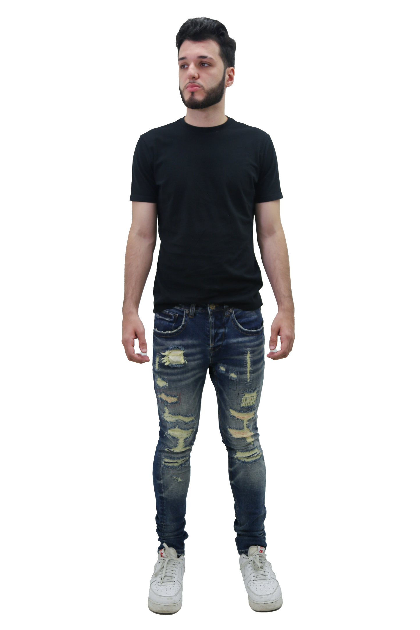 Man wearing RIPPED MID-RISE SKINNY JEANS with a black t-shirt and white sneakers, showcasing a trendy fashion look.