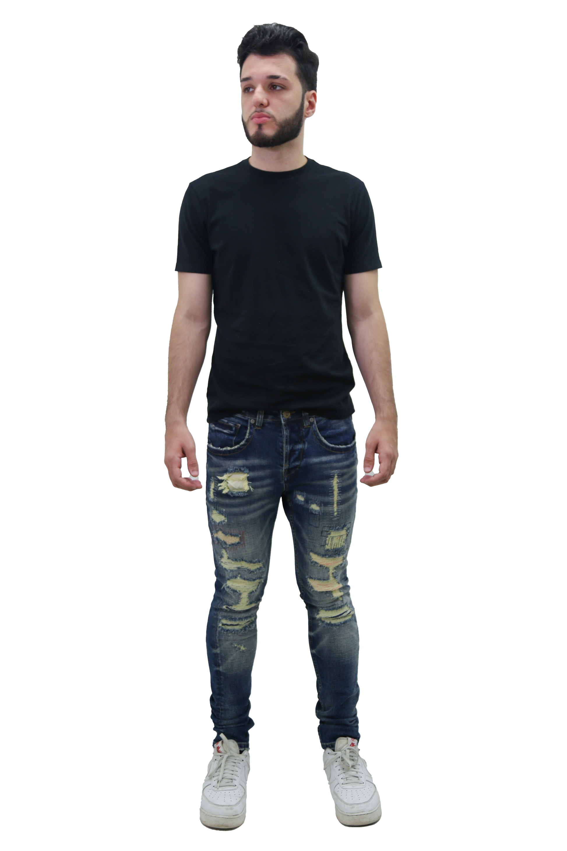 Man wearing RIPPED MID-RISE SKINNY JEANS with a black t-shirt and white sneakers, showcasing a trendy fashion look.