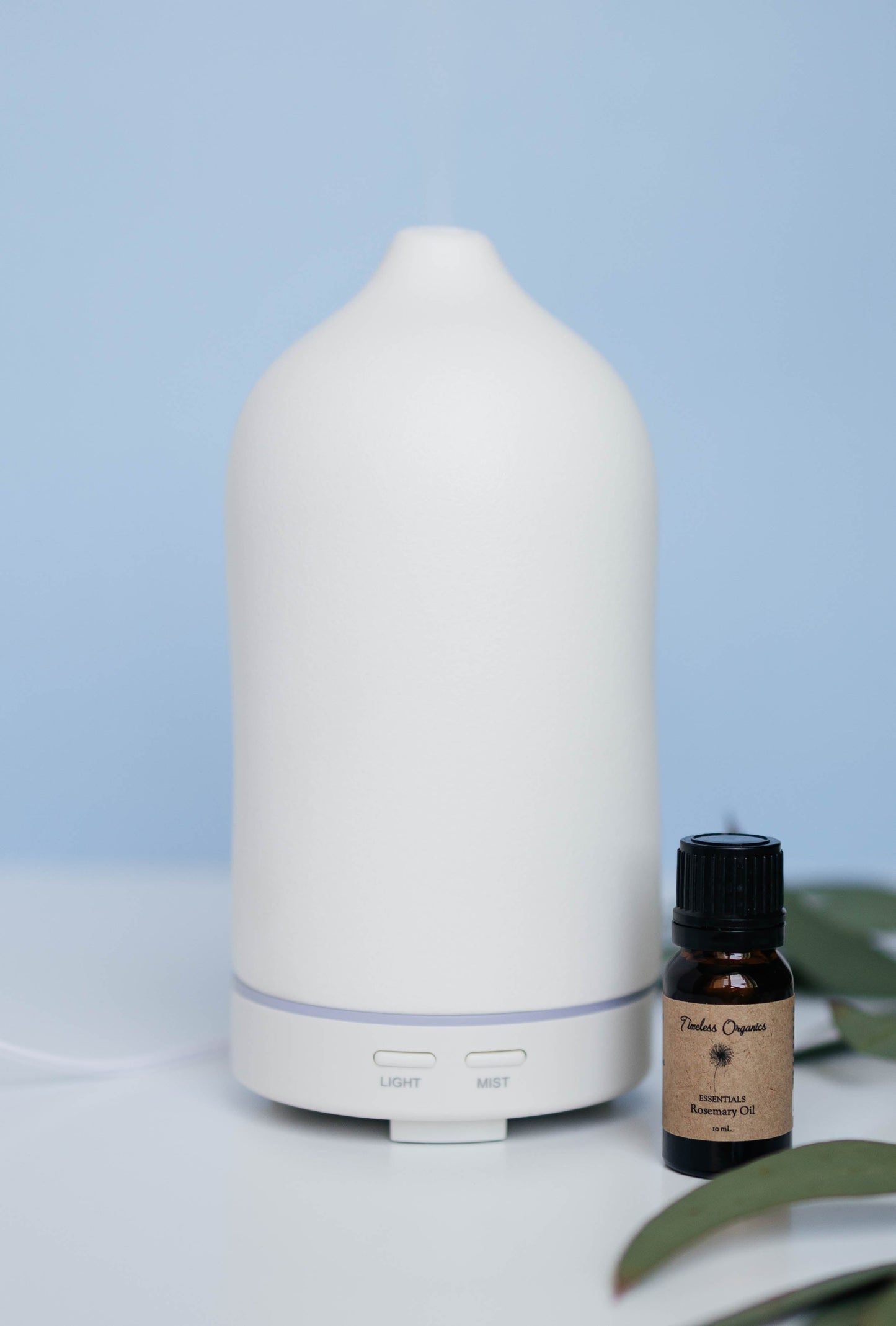 Ceramic Diffuser with essential oil bottle for customizable aromatherapy and ambiance.