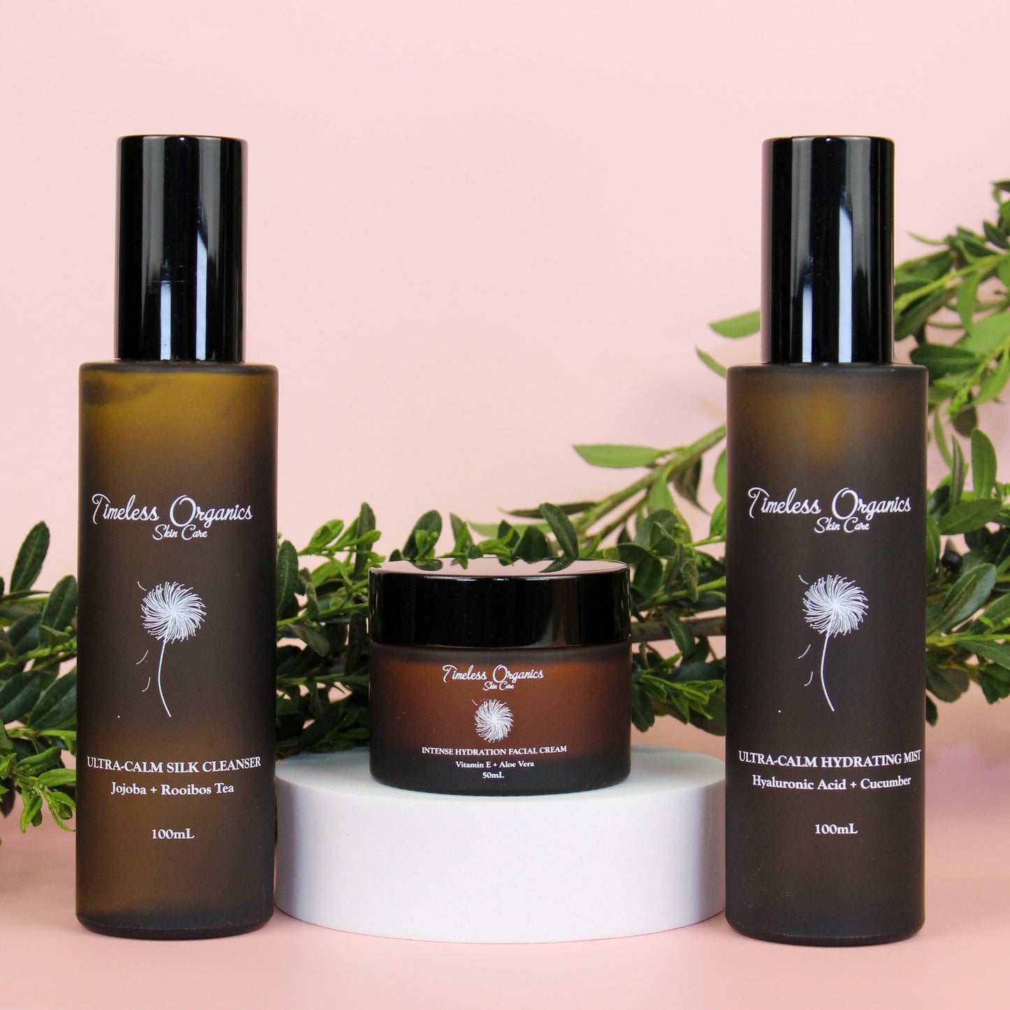 Ultra-Calm Moisturizing Kit with cleanser, toner, and moisturizer for sensitive skin displayed on a pink background with greenery.