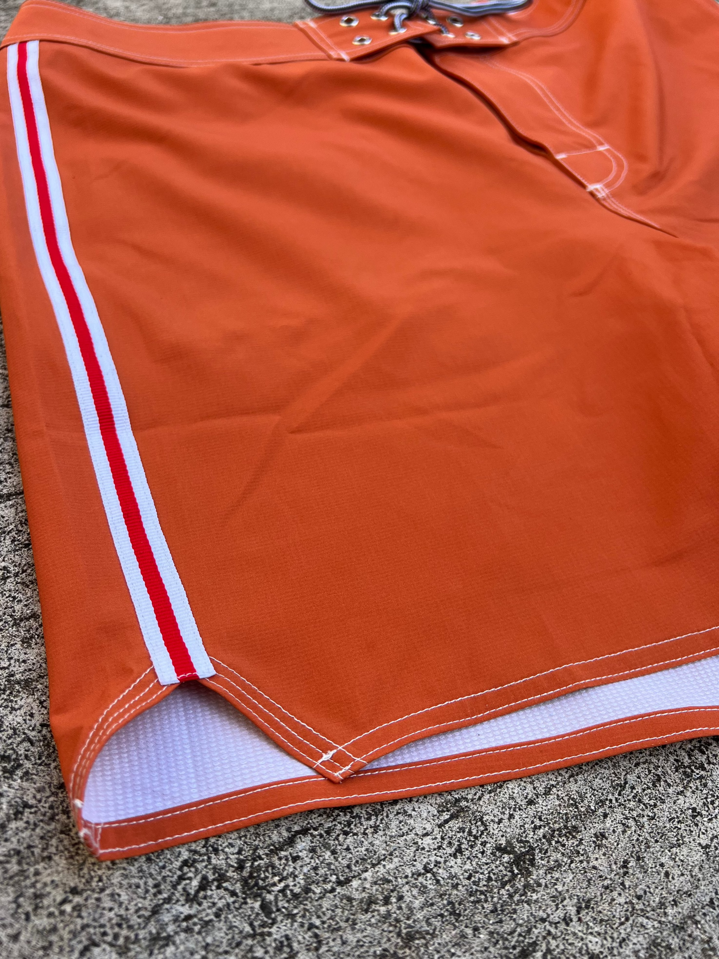 Burnt orange classic boardshort - sunset with red stripe, textured 4-way stretch fabric, ideal for surfing and all-day comfort.