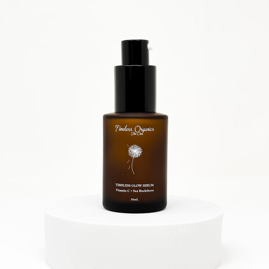 Timeless Glow Serum 30mL bottle on a white pedestal, highlighting nourishing oils and 10% Vitamin C for radiant skin.