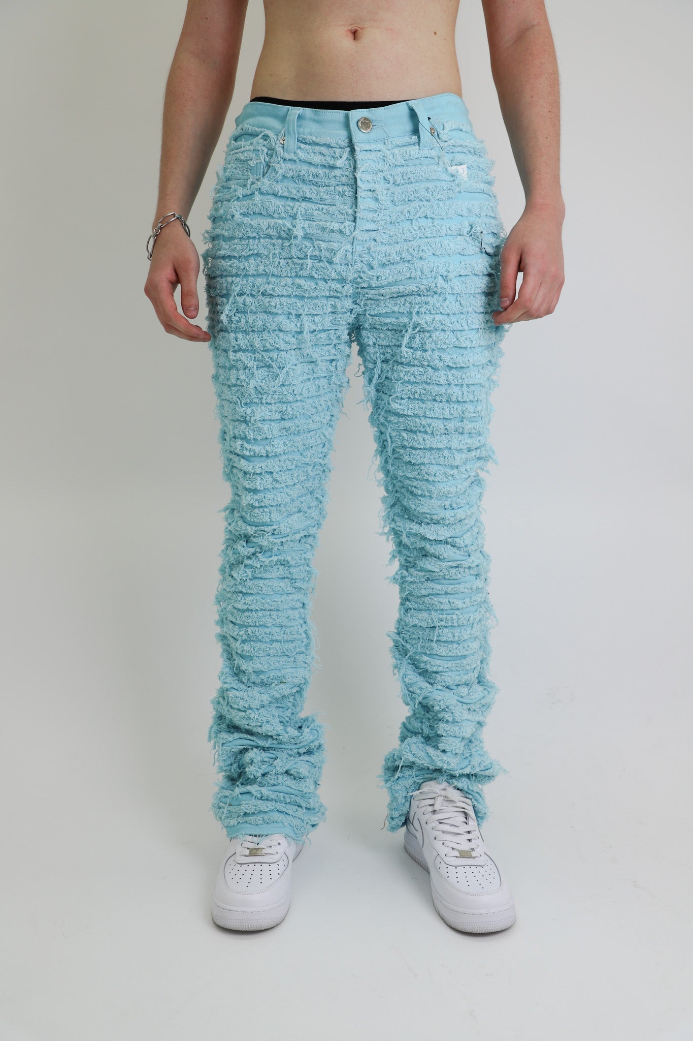 AJS693 EXTREME FRAYED STACKED JEANS with mid-rise waist, stretchy cotton fabric, five-pocket design, and frayed stacked leg style.