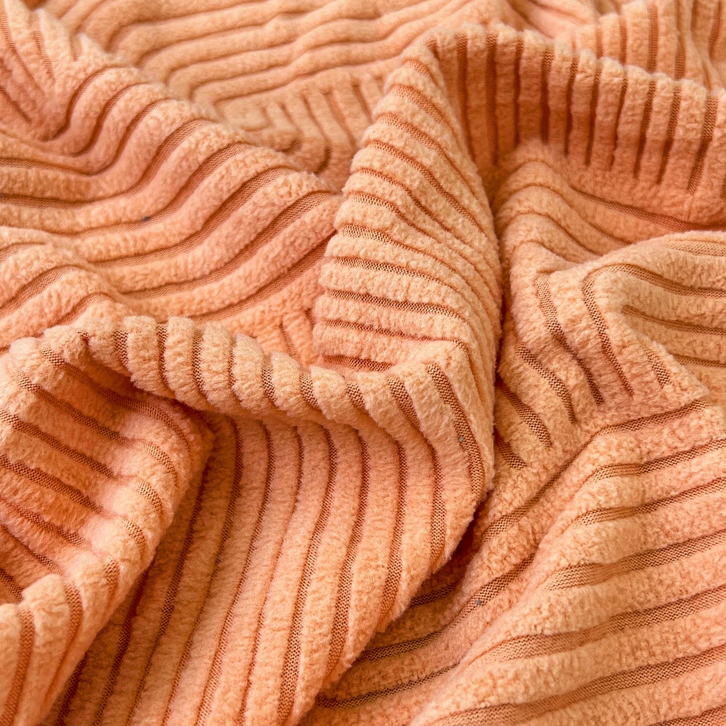 Close-up texture of high-quality stretch elastic fabric in orange for Stretch Couch Cushion Covers, Washable Chaise Lounge Sofa Slipcover.