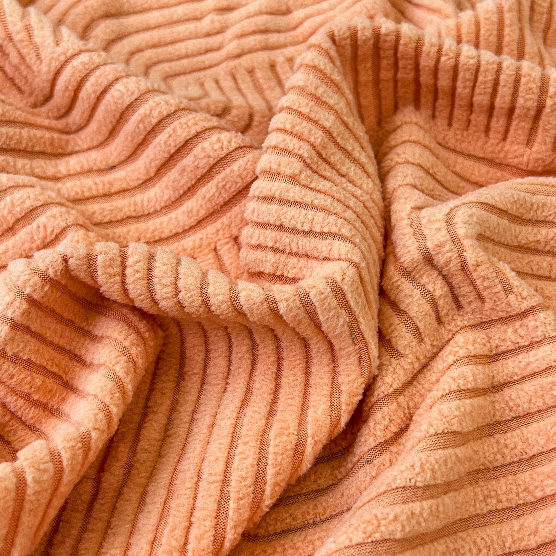Close-up texture of high-quality stretch elastic fabric in orange for Stretch Couch Cushion Covers, Washable Chaise Lounge Sofa Slipcover.