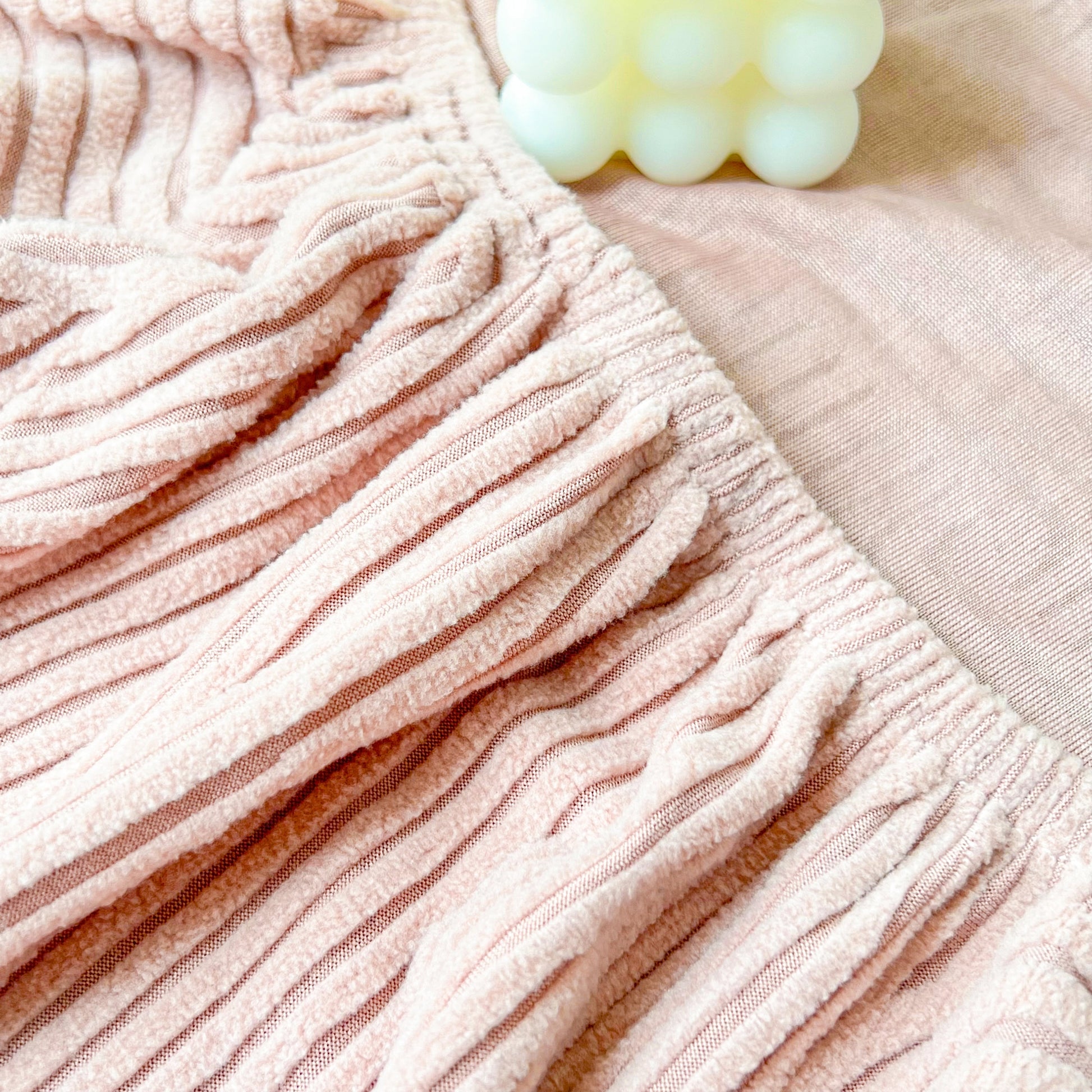 Close-up of pink Stretch Couch Cushion Covers, Washable Chaise Lounge Sofa Slipcover with elastic texture.