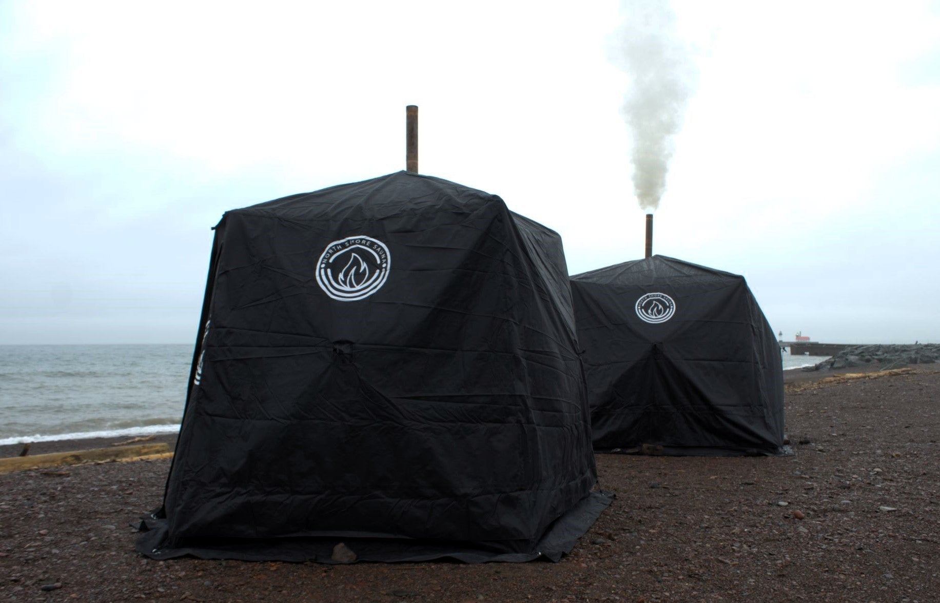 Full Cover for Nova 4 Sauna Tent with window for visibility, protecting tent from elements, shown on beach while sauna is in use.
