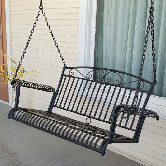 Wrought Iron Outdoor Patio 4-Ft Porch Swing in Black featuring scrolled arms and slatted backrest on a porch.
