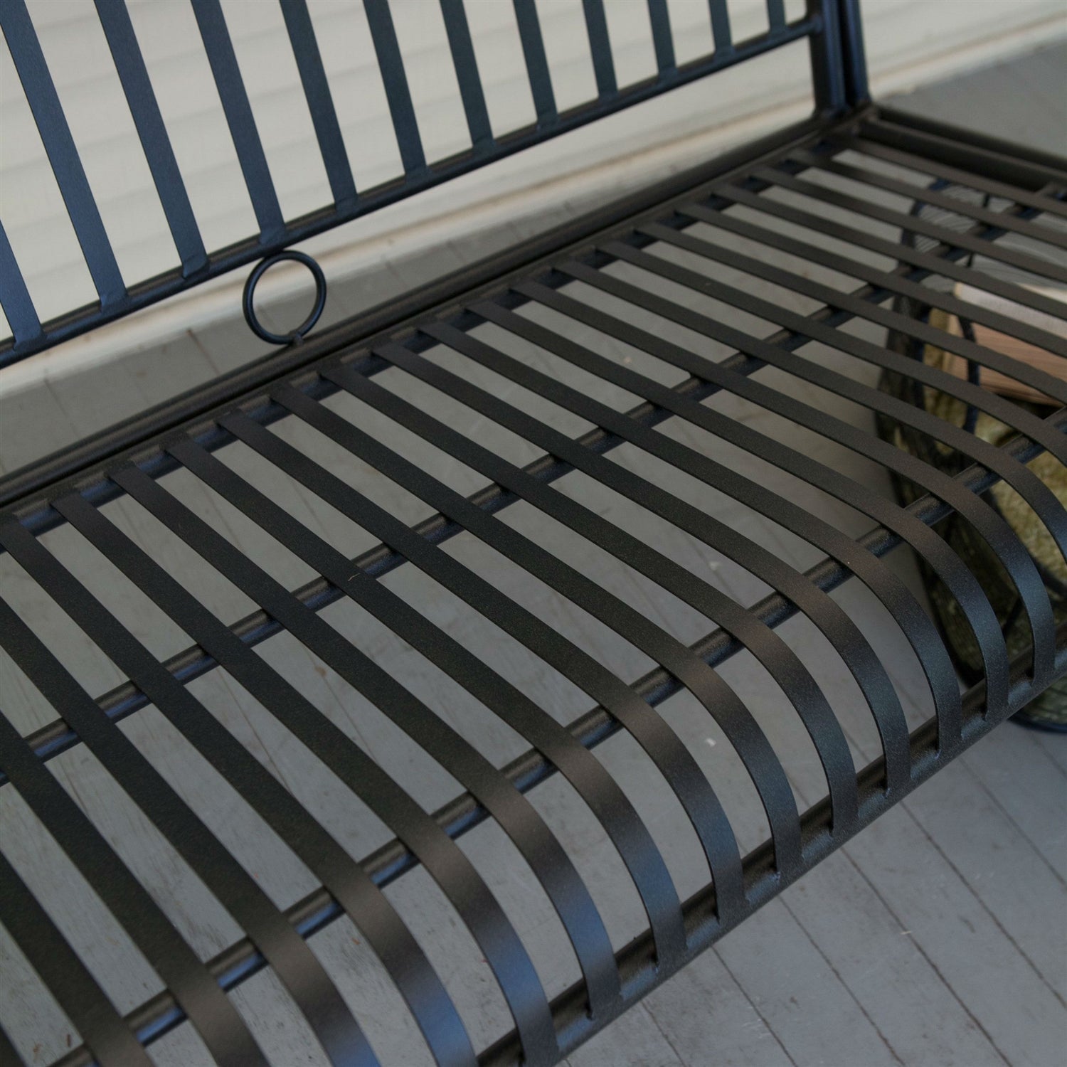 Close-up of Wrought Iron Outdoor Patio 4-Ft Porch Swing in Black with slatted design and powder-coated finish.