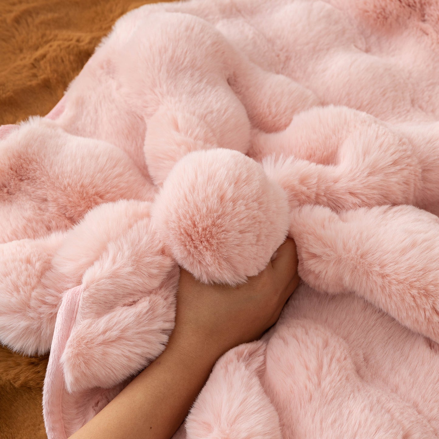 Hand touching Thick Sofa Cushion Solid Color Faux Fur Fluffy Sofa Cushion Non-Slip Couch Covers in soft pink fabric.