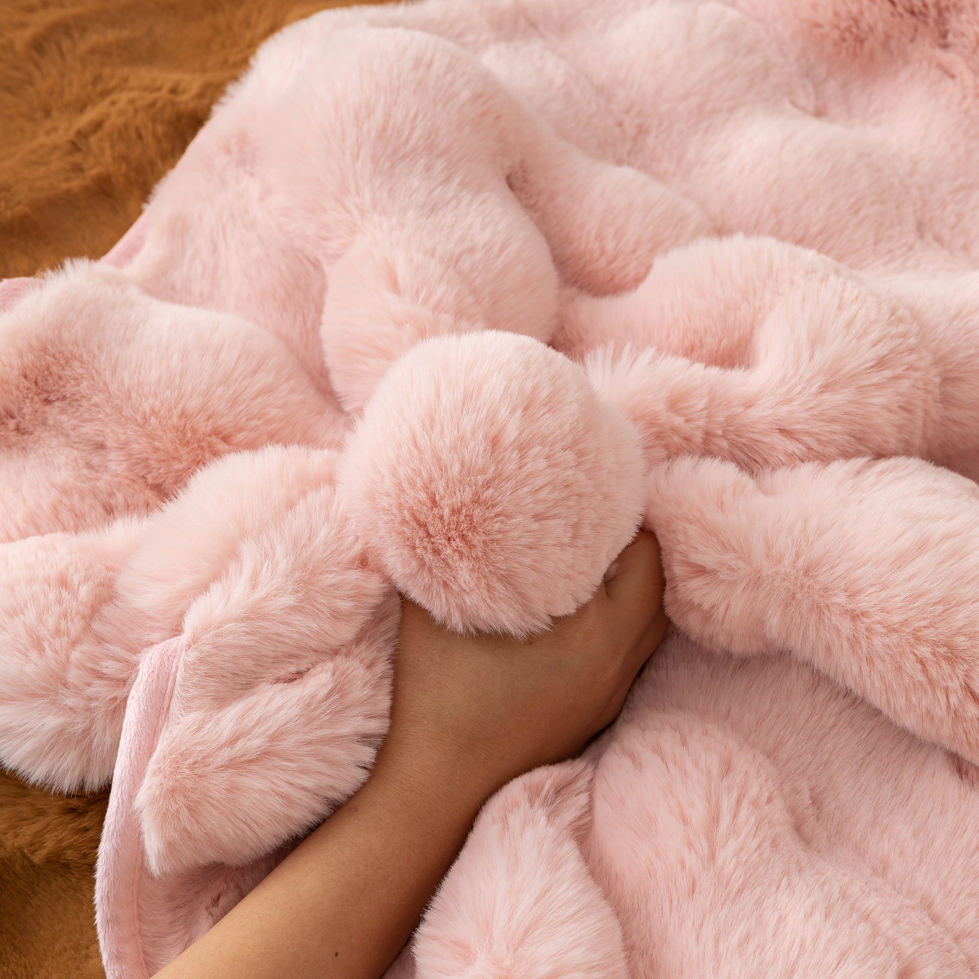 Hand touching Thick Sofa Cushion Solid Color Faux Fur Fluffy Sofa Cushion Non-Slip Couch Covers in soft pink fabric.
