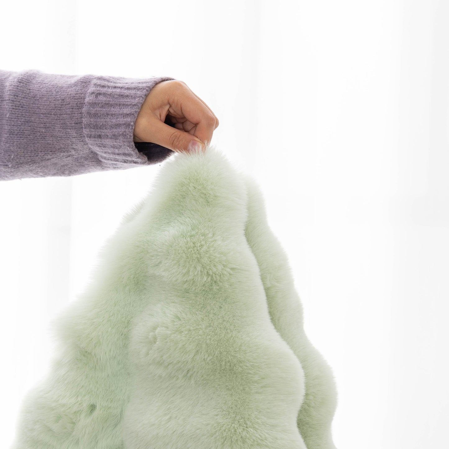Person touching a thick sofa cushion solid color faux fur fluffy sofa cushion non-slip couch covers, showcasing softness and quality.