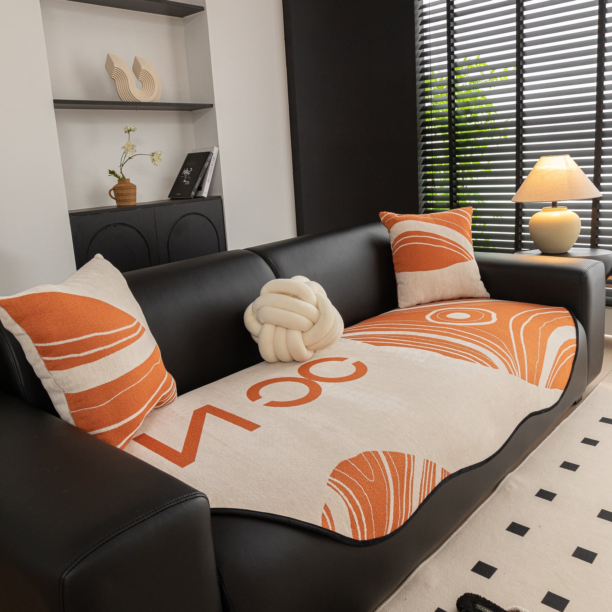 Abstract Art Sofa Cover with Wave Edge, Non Slip Couch Cover for Stylish Homes on a black leather couch.