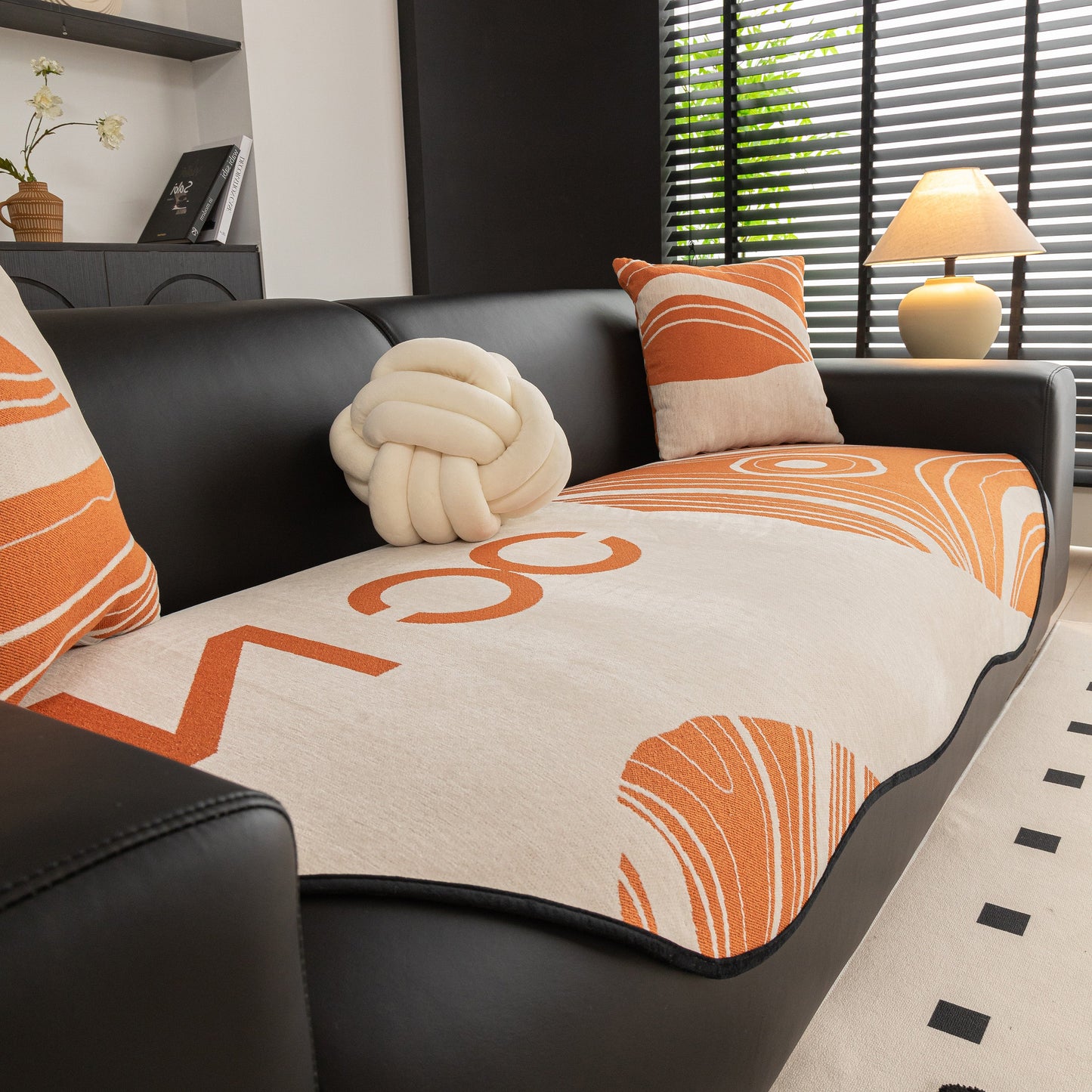 Abstract Art Sofa Cover with Wave Edge, Non Slip Couch Cover for Stylish Homes on black sofa with orange abstract pattern.