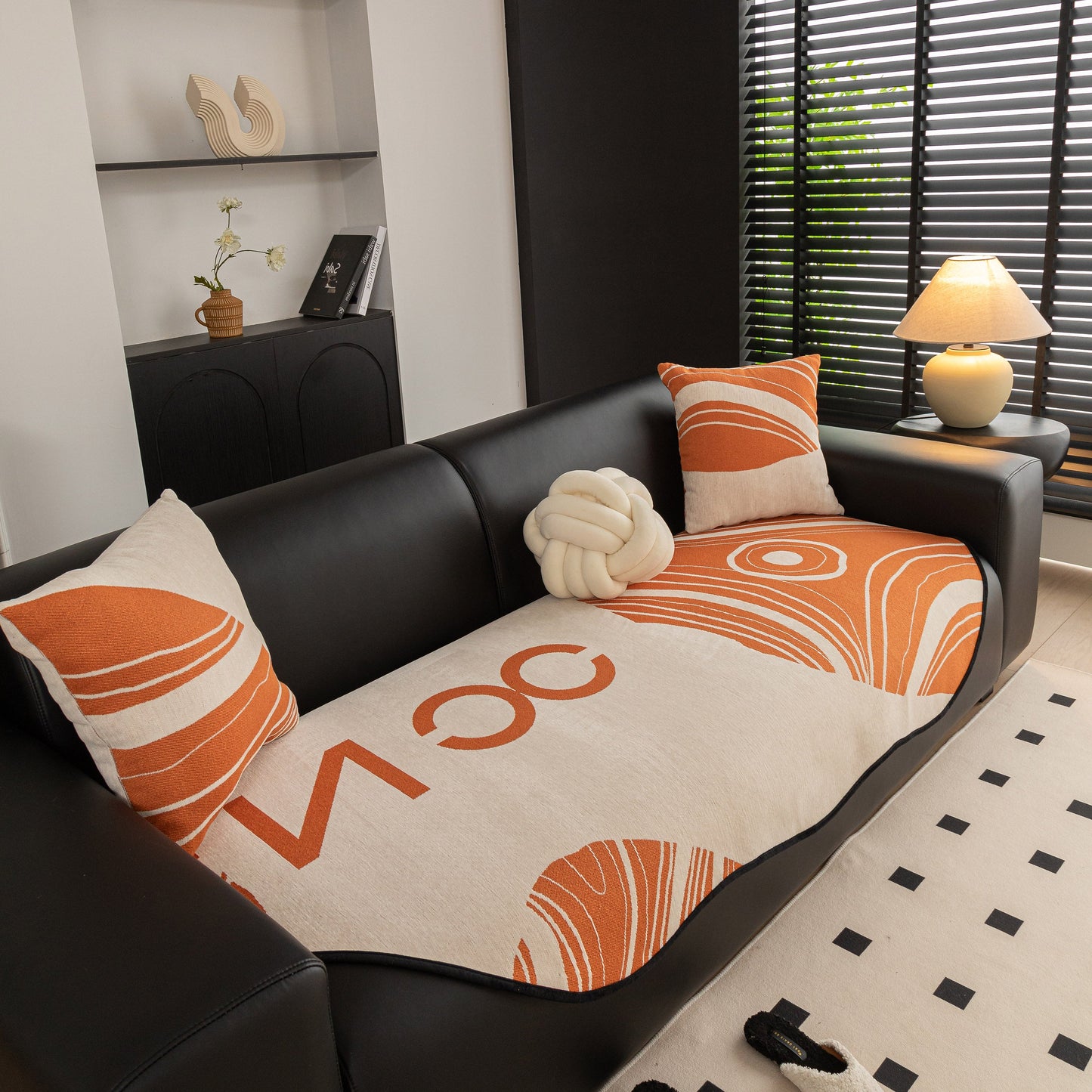 Abstract Art Sofa Cover with Wave Edge, Non Slip Couch Cover for Stylish Homes on black sofa with orange and beige pattern.