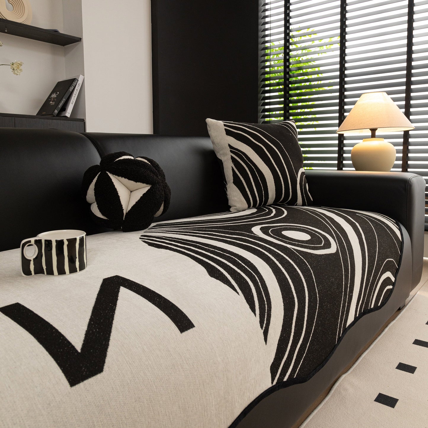 Abstract Art Sofa Cover with Wave Edge, Non Slip Couch Cover for Stylish Homes on modern black sofa in contemporary living room.