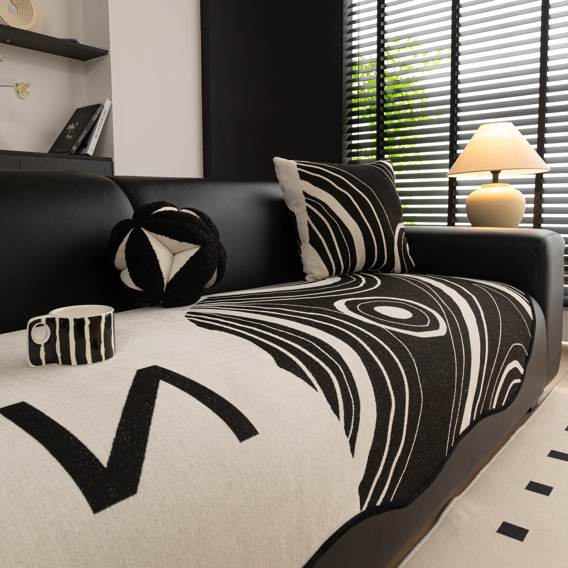 Abstract Art Sofa Cover with Wave Edge, Non Slip Couch Cover for Stylish Homes on modern black sofa in contemporary living room.