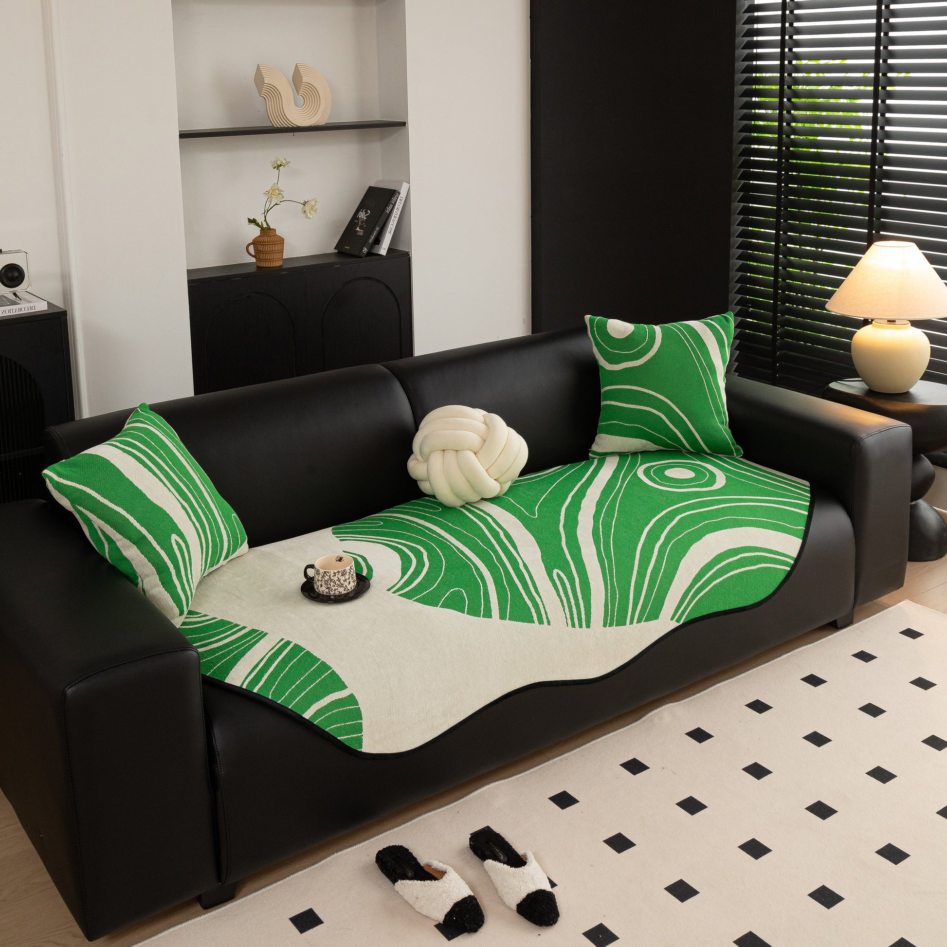 Abstract Art Sofa Cover with Wave Edge, Non Slip Couch Cover for Stylish Homes in green and white abstract pattern on a black sofa.