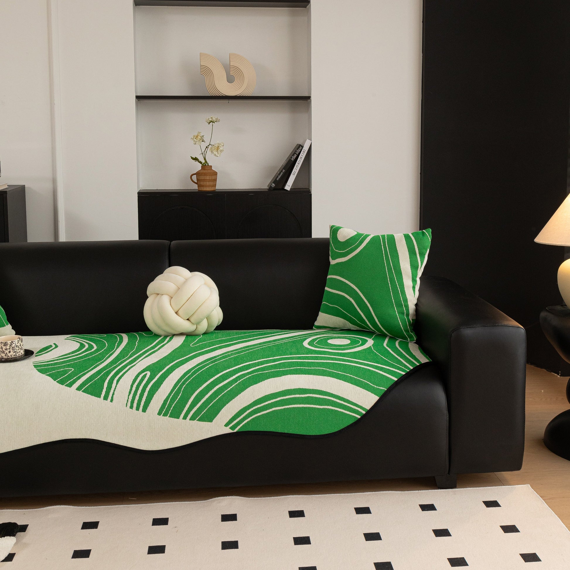 Abstract Art Sofa Cover with Wave Edge on a black couch, non slip design ideal for stylish homes, featuring bold green patterns.