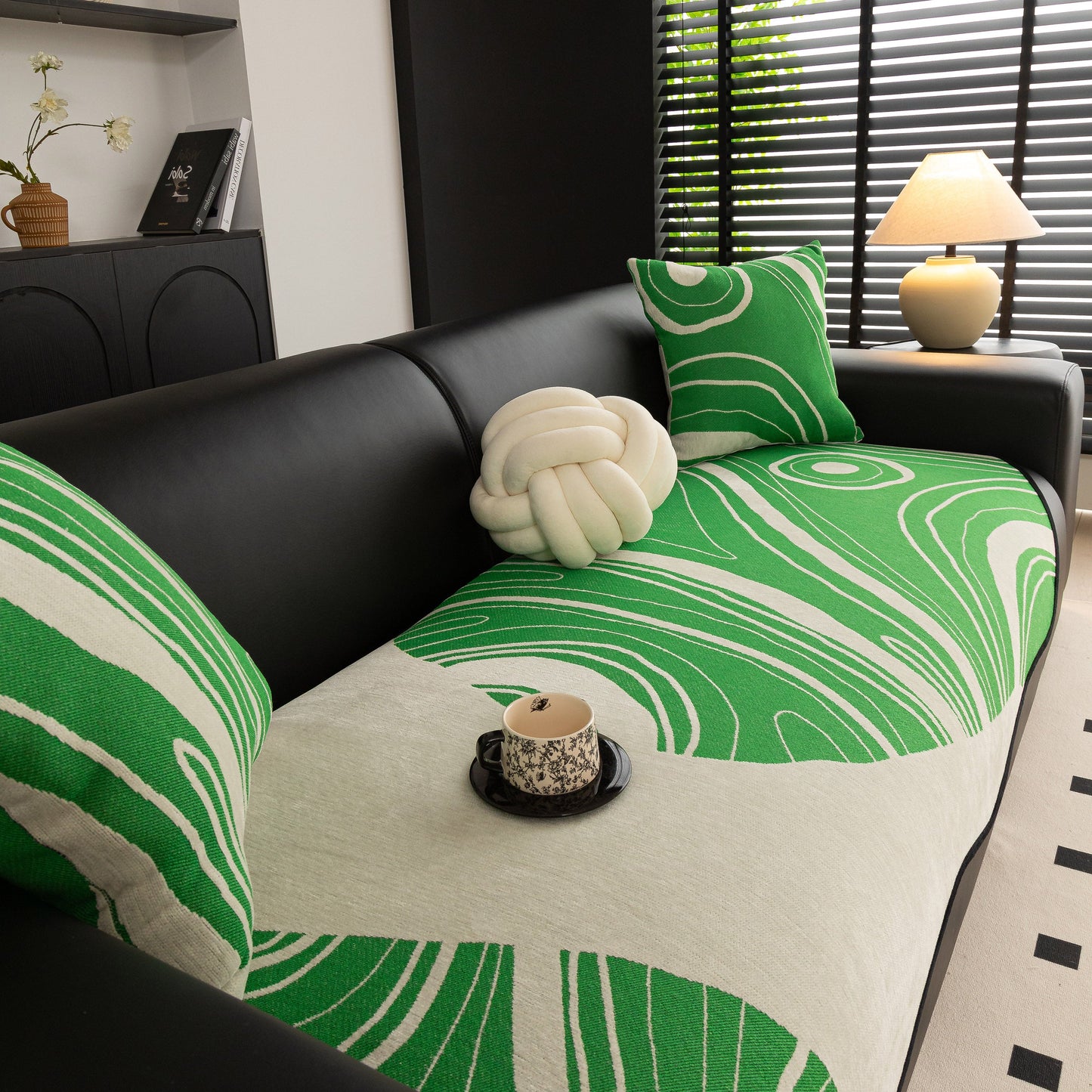 Abstract Art Sofa Cover with Wave Edge, Non Slip Couch Cover for Stylish Homes in green abstract pattern on a black sofa.