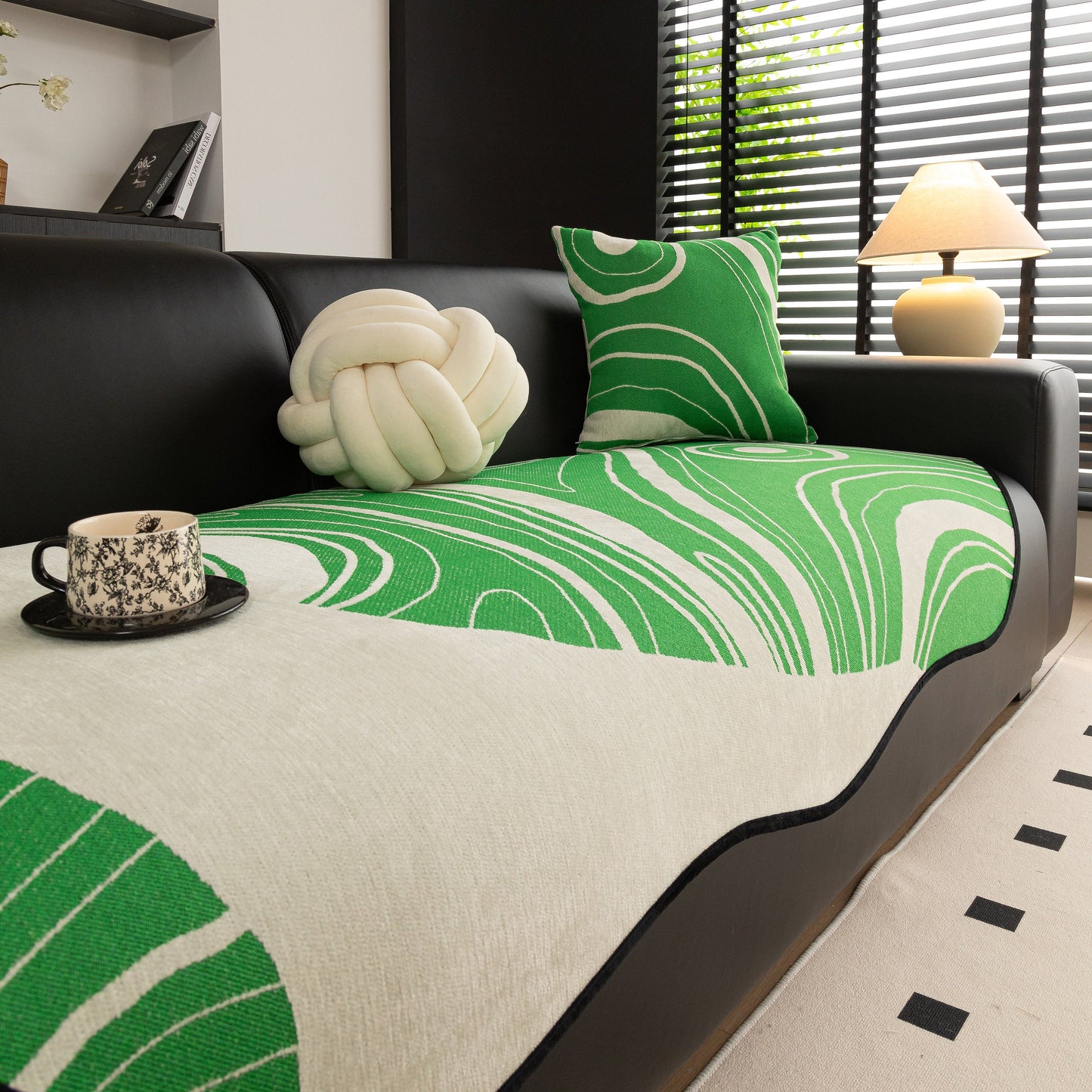 Abstract Art Sofa Cover with Wave Edge, Non Slip Couch Cover for Stylish Homes in green and white on a black sofa.