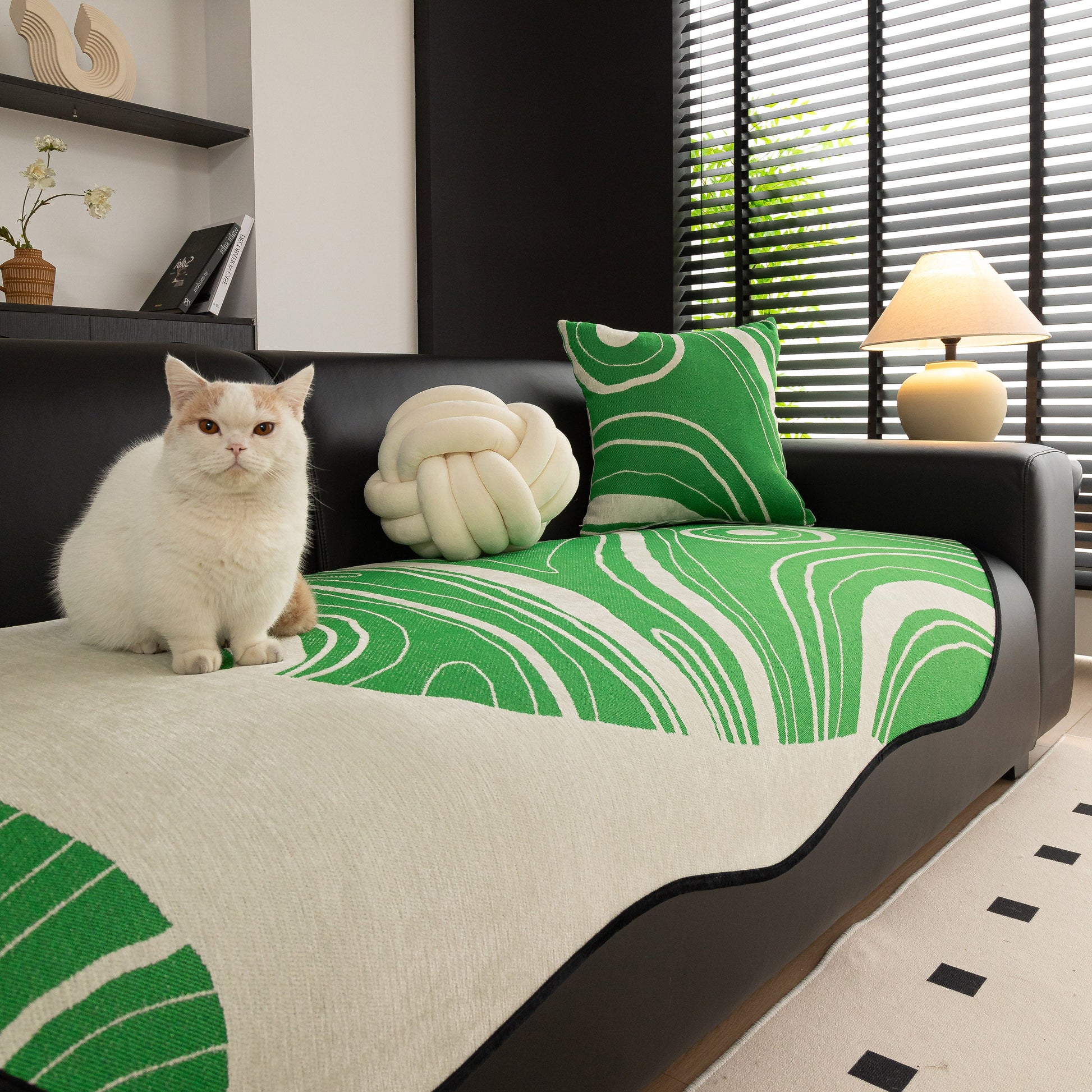 Abstract Art Sofa Cover with Wave Edge, Non Slip Couch Cover for Stylish Homes in green and white pattern on black sofa with cat and cushion.