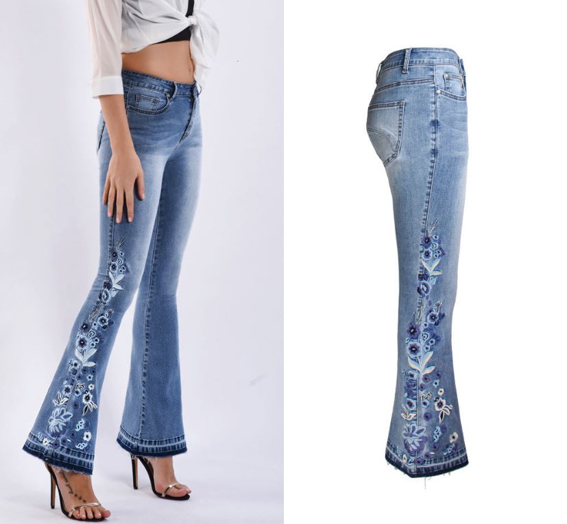 Model wearing "Riley" Flared Denim Jeans in light blue with embroidered details, showing front and side view of the stylish design.