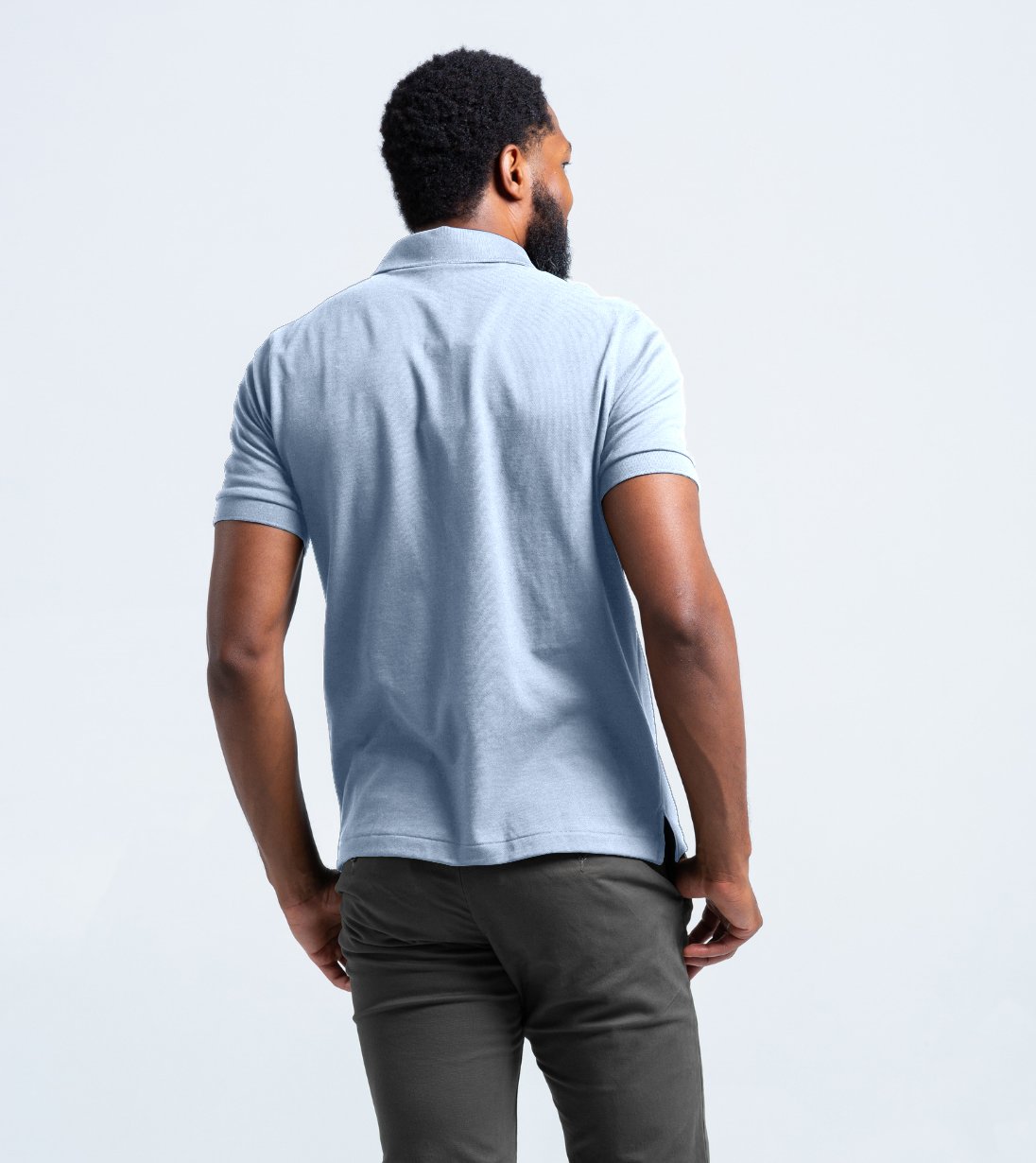 Back view of a man wearing a Short Sleeve Perfect Polo in light blue, showcasing its comfortable fit and stylish design.