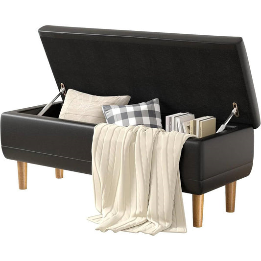 Modern Mid-Century Black Faux Leather End of Bed Storage Bench Ottoman with open lid displaying pillows and books