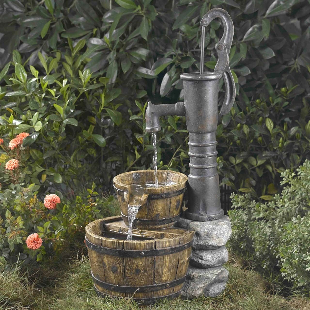 Outdoor Water Pump Half Whiskey Barrel Style Water Fountain with antique design in a garden setting with flowers and foliage.