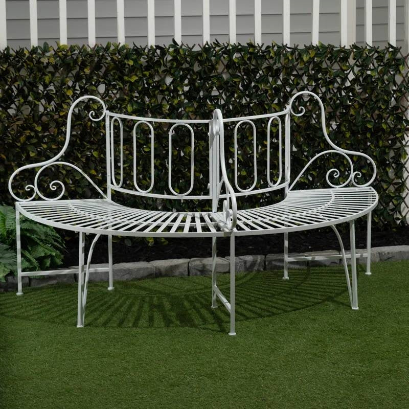Half-Circle White Metal Outdoor Patio Garden Tree Bench with intricate detailing on grass in a garden setting