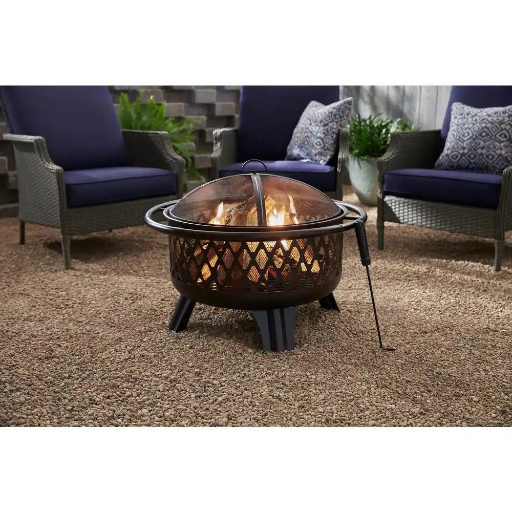 30-inch Black Steel Outdoor Fire Pit Grill with Screen and Poker on a patio, surrounded by chairs, showing a roaring fire.
