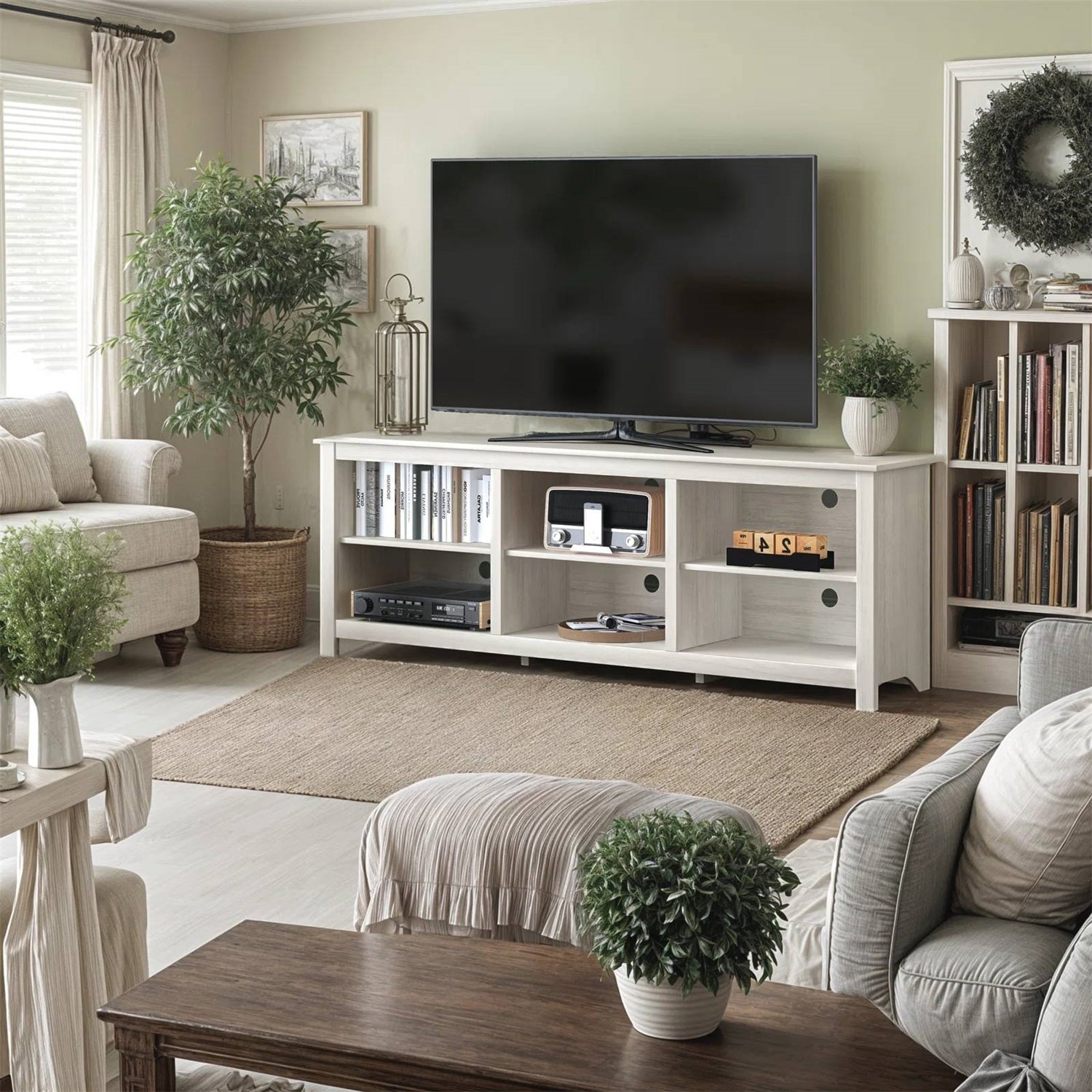 Farmhouse TV Stand in White Wood Grain Finish - for TVs up to 70-inch in a cozy living room setting with decor and greenery.