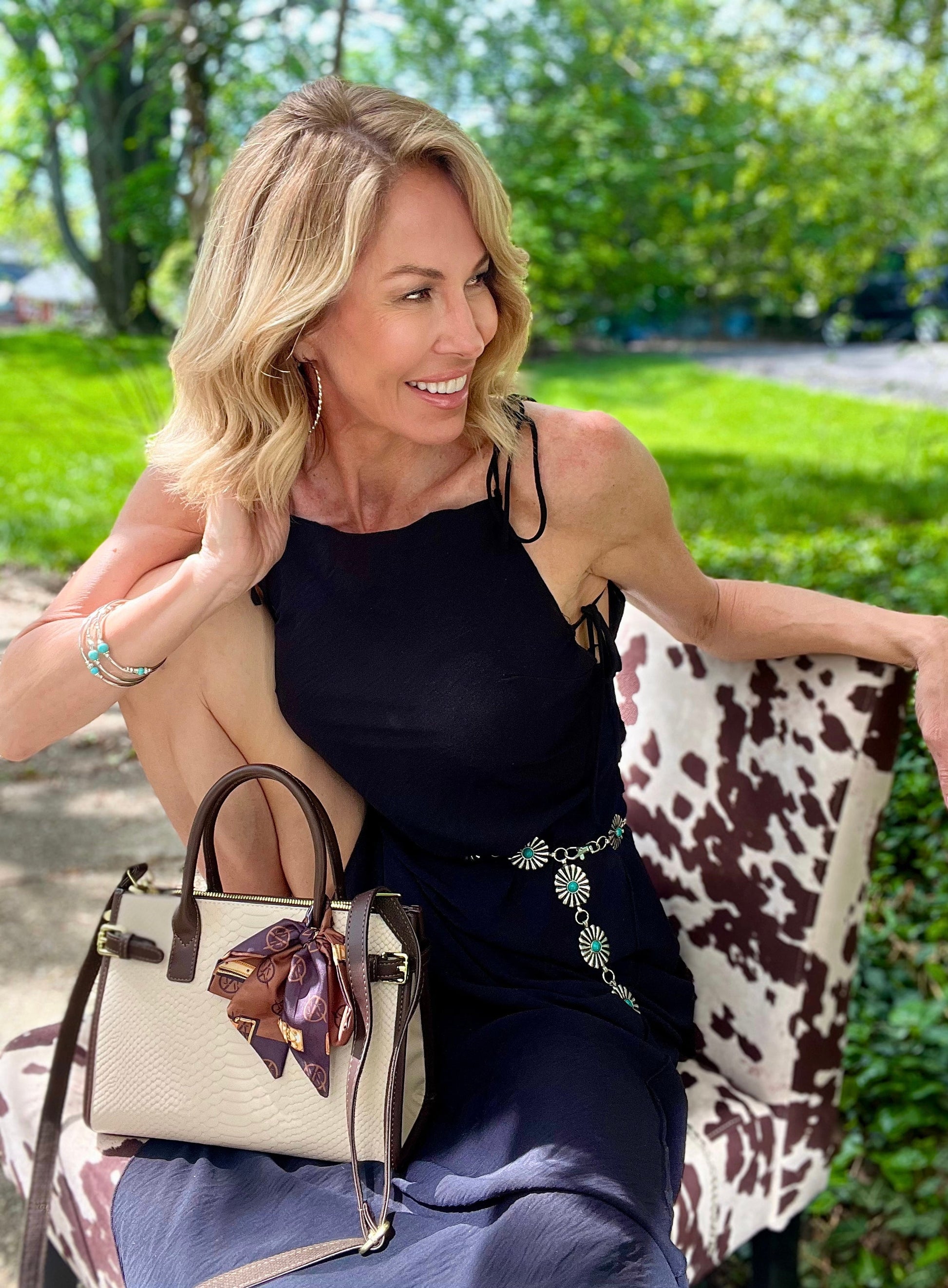 Woman sitting with Serpent Luxe Snakeskin Handbag - Elegant Leather Commuter Bag for Stylish Women on a patterned chair.