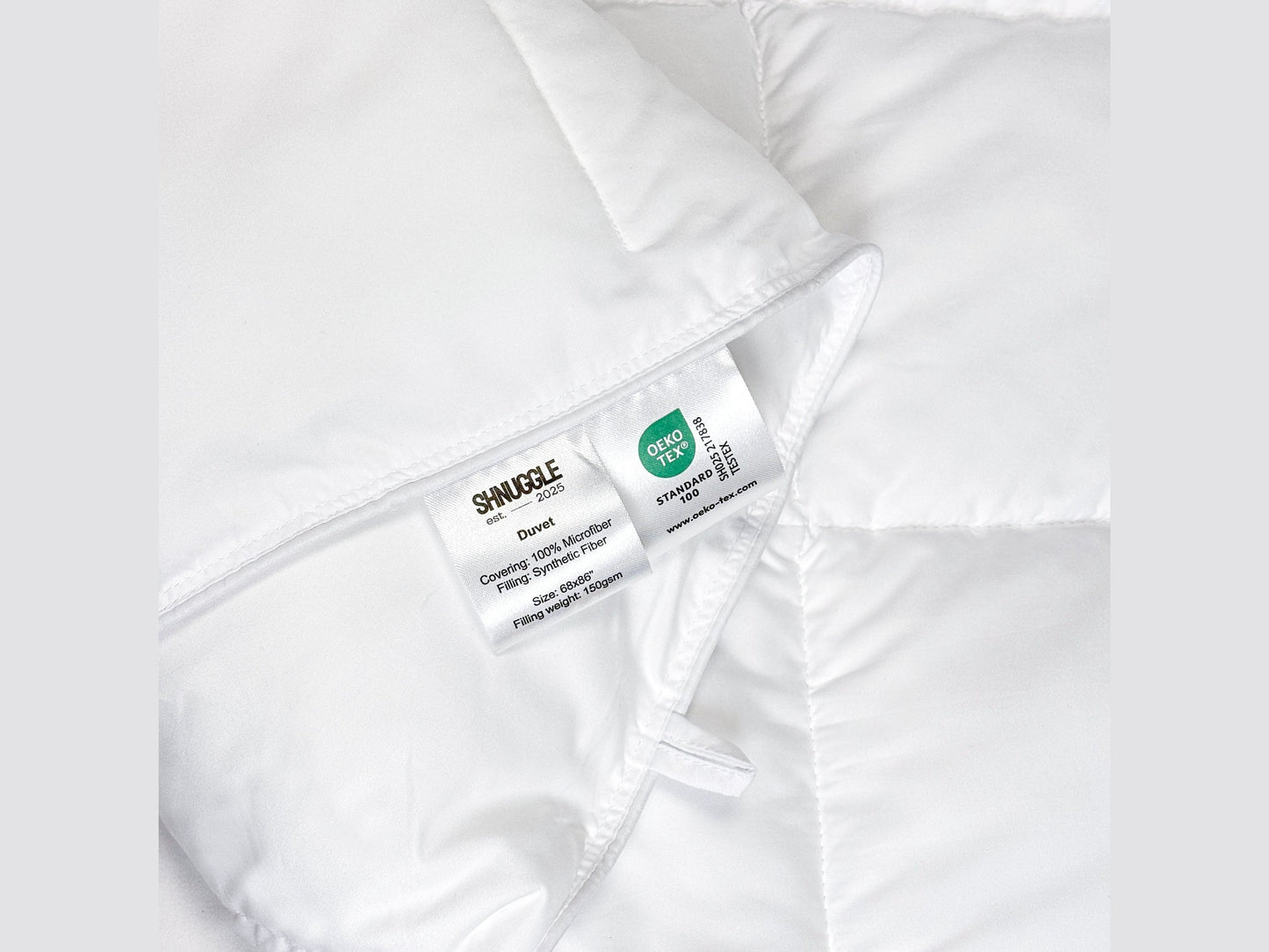 Close-up of SHNUGGLE SNAP-EZ Quilt label showing washing instructions, emphasizing its ease of care and practicality.
