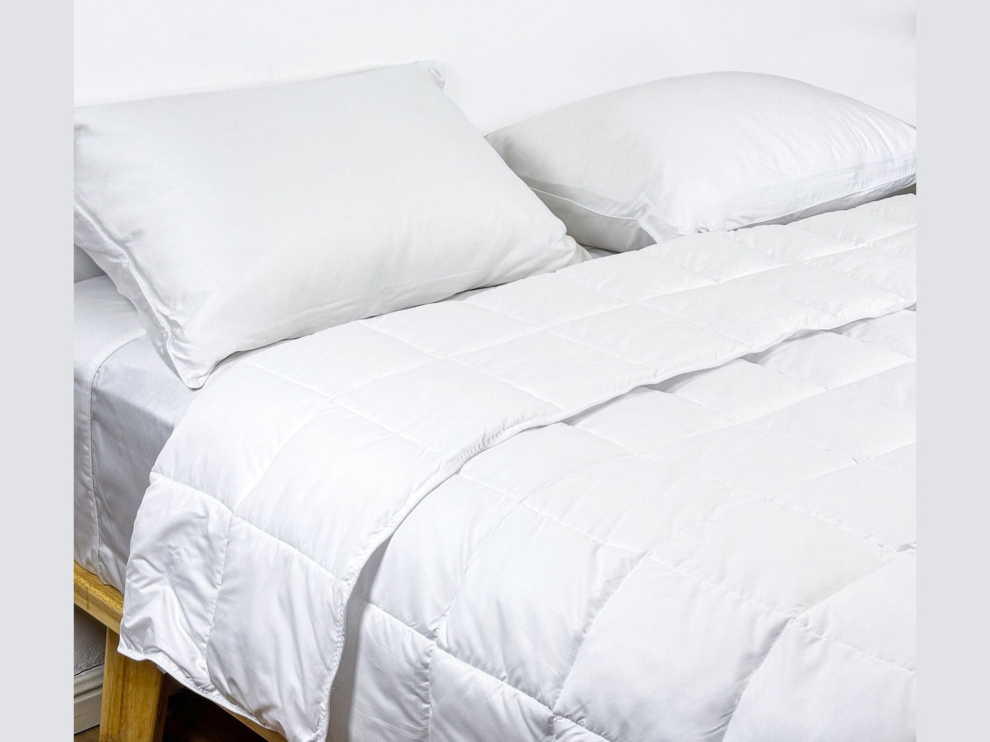 SHNUGGLE SNAP-EZ Quilt on bed with pillows, showcasing its lightweight, soft feel for cozy and practical bedtime comfort.