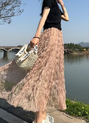 Woman wearing elegant Midi Mesh Skirt with layered tulle, standing by a lake.