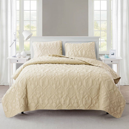 Queen Coastal Beach Starfish Seashells Seahorse Sand Tan 3-Piece Quilt Set on bed with shams displaying embossed sea life pattern.