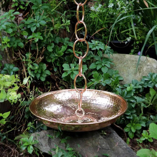 Hand Hammered Copper Polished Rain Chain Basin - 16.5 inch Diameter in a garden setting