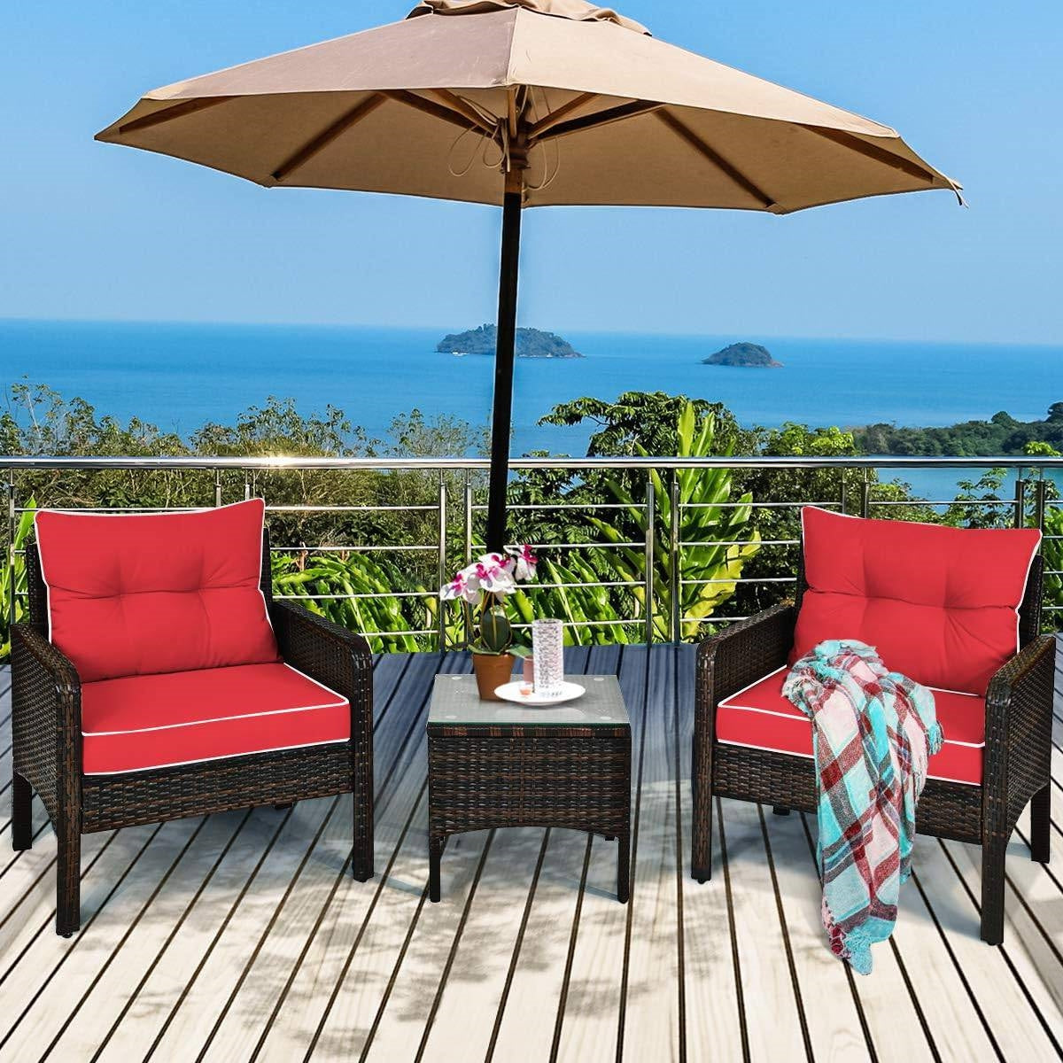 3-Piece Brown PE Rattan Outdoor Dining Patio Furniture Set with Red Cushions on a deck overlooking the ocean