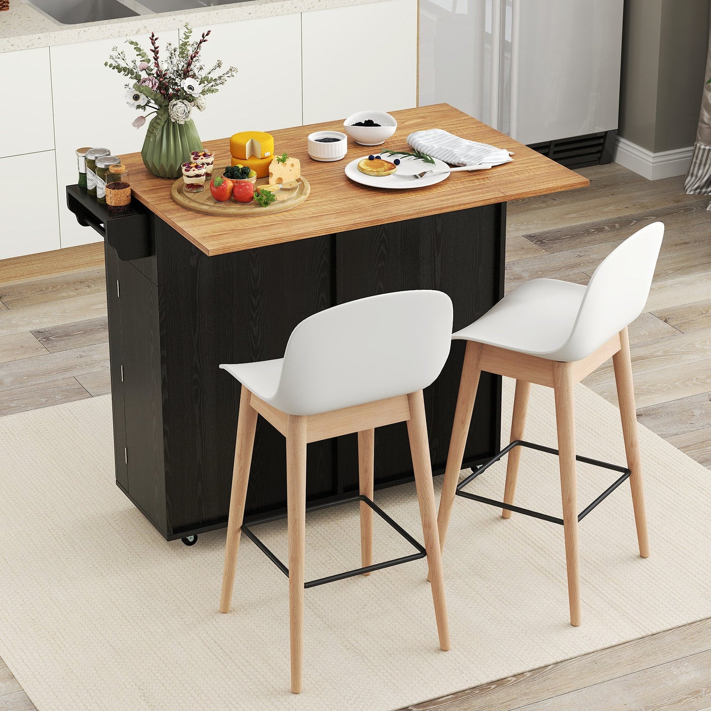Rolling Kitchen Island with Trash Can Cabinet and Rubber Universal Wheels-Black in a modern kitchen setting with dishes on top.