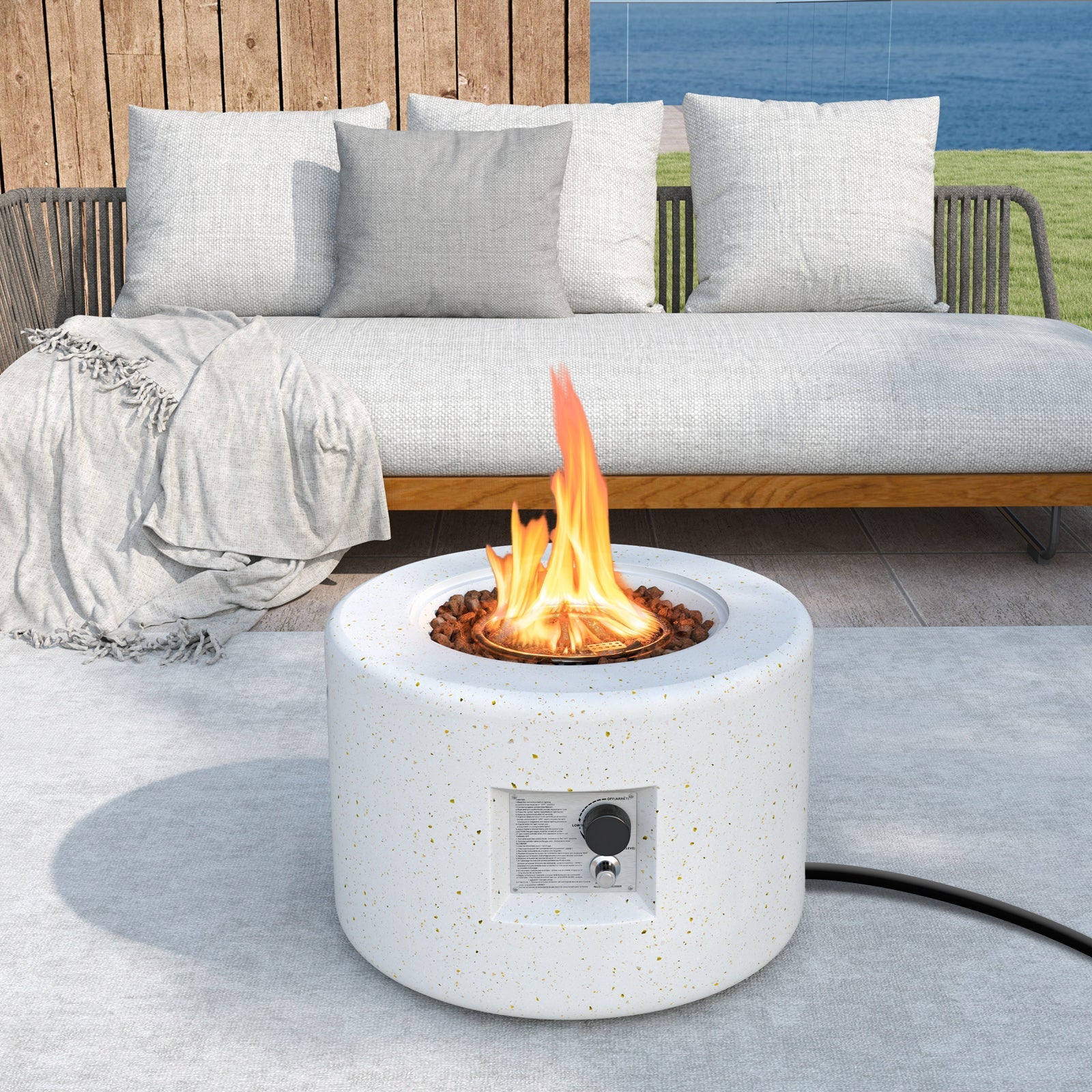 Round Terrazzo Propane Gas Fire Pit with Hideaway Tank Holder and Lava Rocks on patio.
