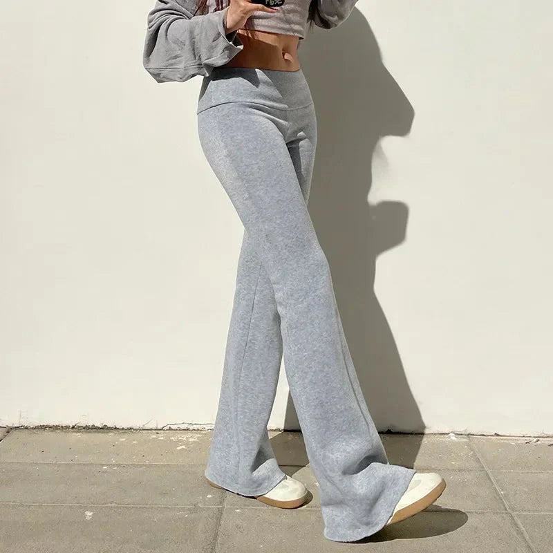 Woman wearing Low-Waisted Solid Flare Boot-Cut Pants Women in gray, showcasing Y2K street-style fashion.