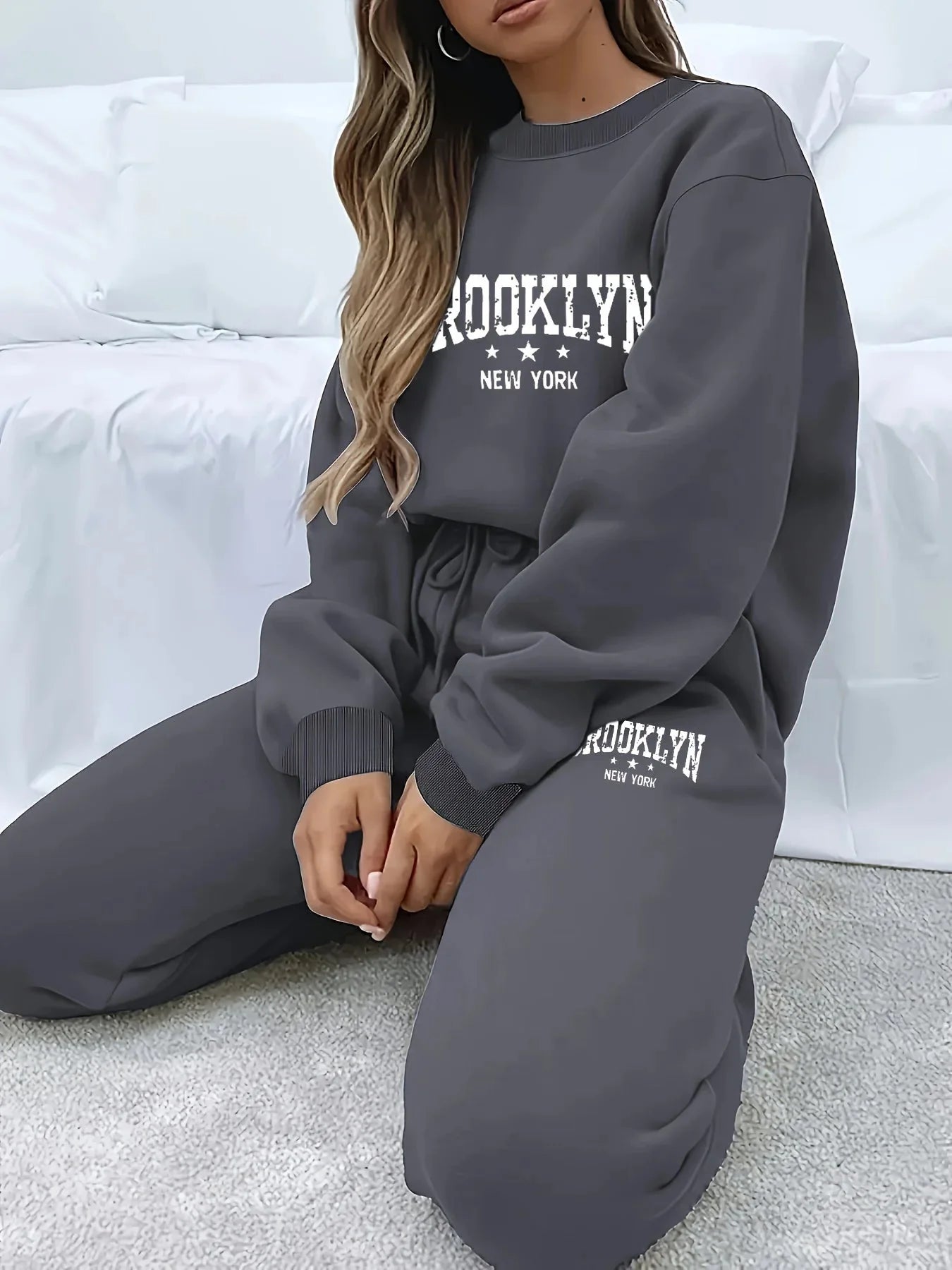 Woman wearing Women’s Plush Hoodie & Pants Sweater Set – Cozy Winter Tracksuit in dark color, sitting comfortably on sofa