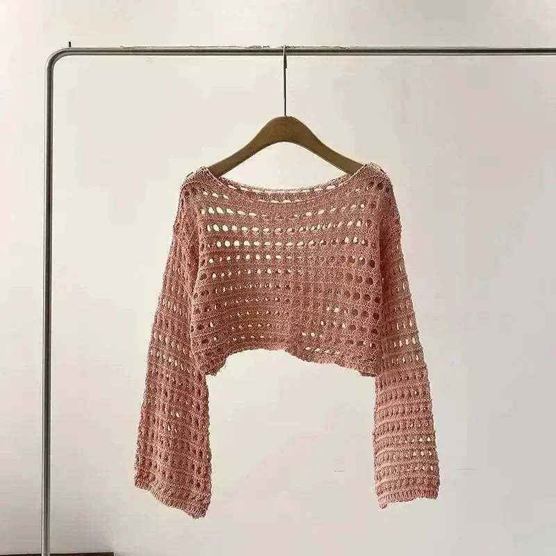 Women's crochet knit beach cover up in pink, boho chic long sleeve crop top for summer vacations and festivals.