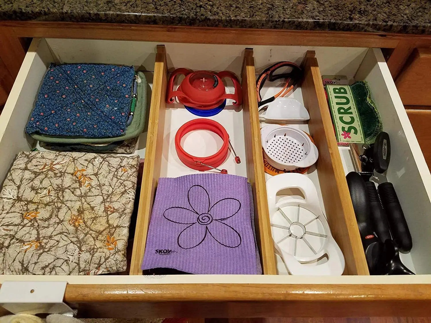 Bamboo Expandable Strip Bamboo Drawer Partition in kitchen drawer organizing dish cloths and cooking tools.