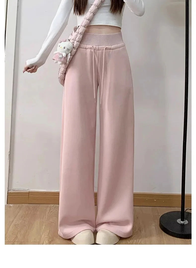 Pink high-waist loose wide-leg pants for women paired with a white top and plush bag.
